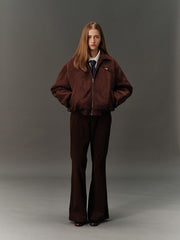 詳細画像: スエード調素材の滑らかな表面とキルティング加工による保温性を示すディテールクローズアップ画像。フラップカラーや多機能ポケットのデザインが際立つ。
モデル画像: スエード調ショート丈ダウンジャケットを着用したモデルのコーディネート例。レトロなブラウンカラーがヴィンテージ感を演出し、カジュアルパンツやワークパンツと相性抜群な秋冬スタイル。