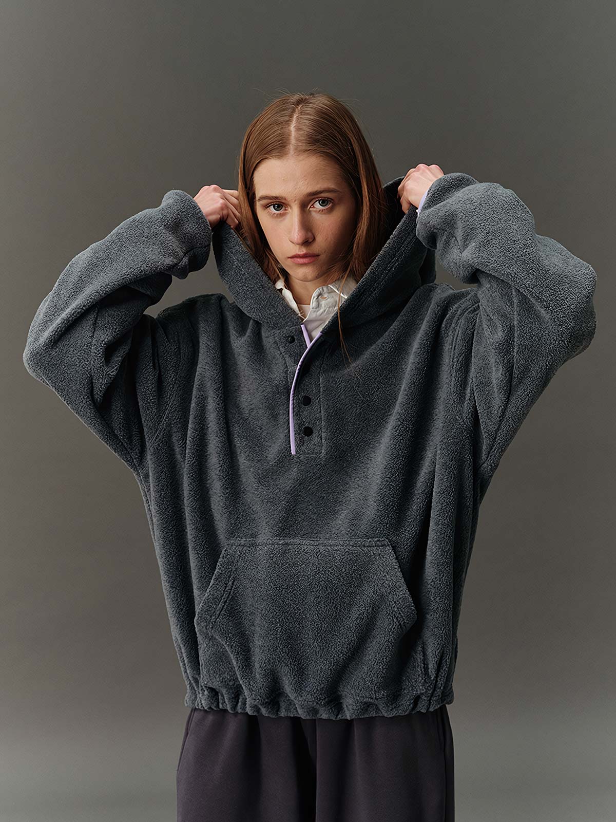 詳細画像: ハーフジップデザインと、シルエット調節可能な裾ドローコードのディテールクローズアップ画像。柔らかなフリース素材の質感が際立つ。
モデル画像: ハーフジップフリースフード付きスウェットを着用したモデルのコーディネート例。デニムやスウェットパンツと合わせたカジュアルでトレンド感あふれるスタイリングを表現。