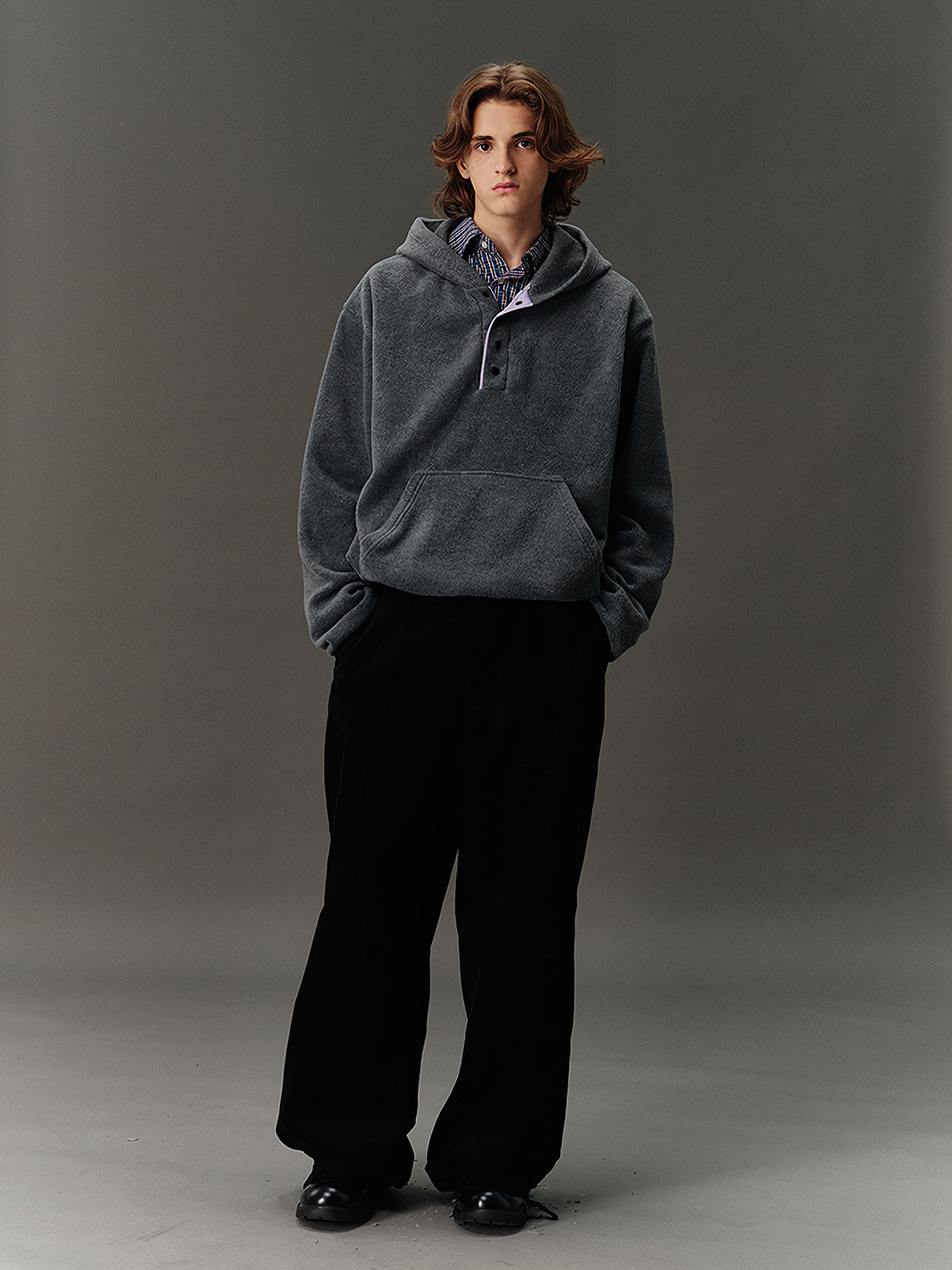詳細画像: ハーフジップデザインと、シルエット調節可能な裾ドローコードのディテールクローズアップ画像。柔らかなフリース素材の質感が際立つ。
モデル画像: ハーフジップフリースフード付きスウェットを着用したモデルのコーディネート例。デニムやスウェットパンツと合わせたカジュアルでトレンド感あふれるスタイリングを表現。