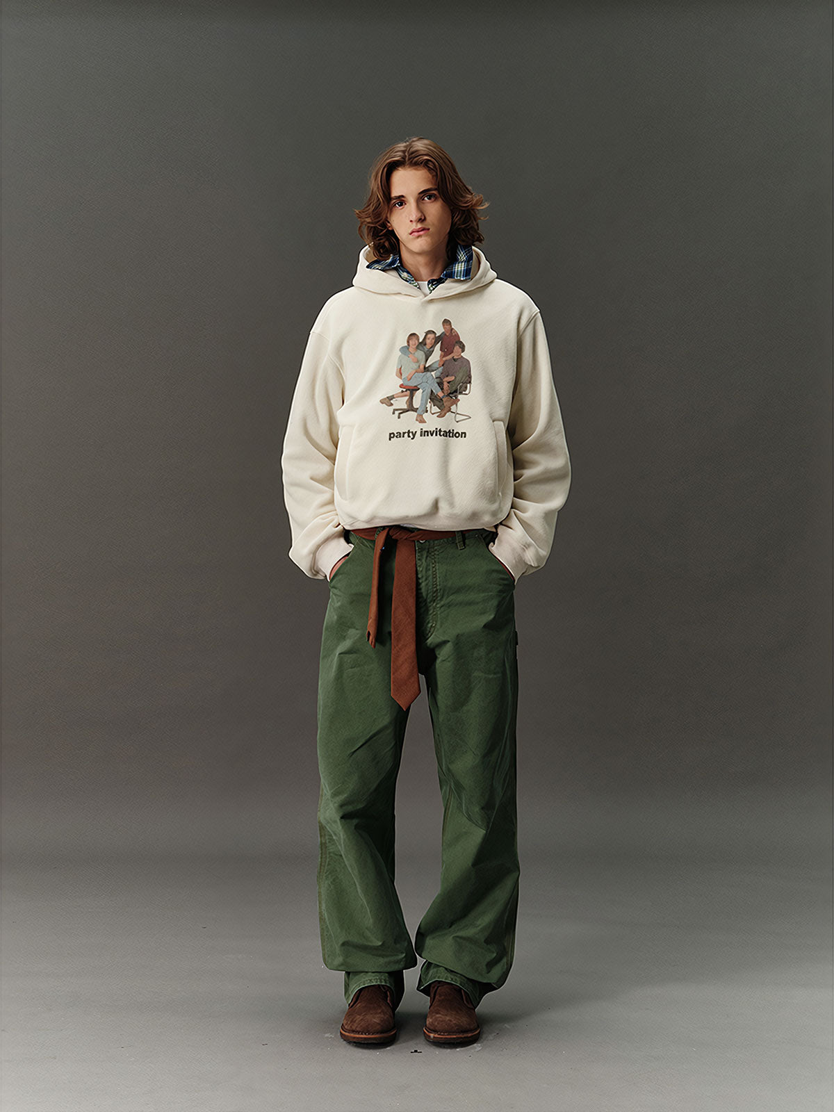 詳細画像: 胸元に施されたレトロなデジタルプリントのディテールと、高品質フリース素材の滑らかな質感のクローズアップ画像。快適な着心地が伝わる生地感をアピール。
モデル画像: フード付きスウェットを着用したモデルのコーディネート例。デニムやカジュアルパンツとの組み合わせで、アメカジレトロやストリートスタイルを演出した秋冬のスタイリングイメージ。