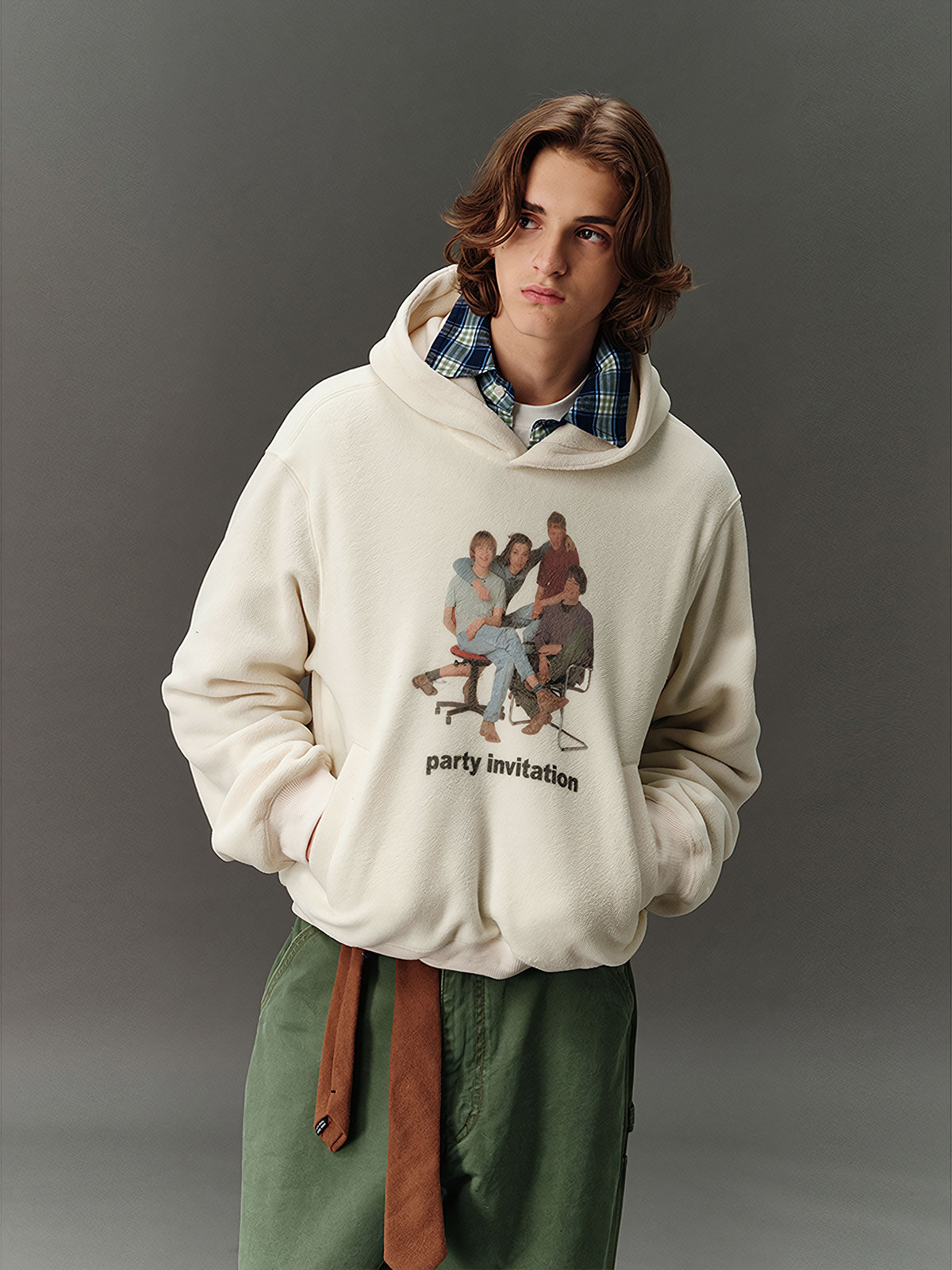 詳細画像: 胸元に施されたレトロなデジタルプリントのディテールと、高品質フリース素材の滑らかな質感のクローズアップ画像。快適な着心地が伝わる生地感をアピール。
モデル画像: フード付きスウェットを着用したモデルのコーディネート例。デニムやカジュアルパンツとの組み合わせで、アメカジレトロやストリートスタイルを演出した秋冬のスタイリングイメージ。