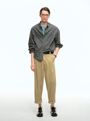 詳細画像: ウエストのプリーツディテールとサンドウォッシュ加工のクローズアップ、自然な色褪せ感と立体感を強調
モデル画像: モデルが九分テーパードカジュアルパンツを着用し、ヴィンテージファッションスタイルを演出、シンプルで洗練されたコーディネート