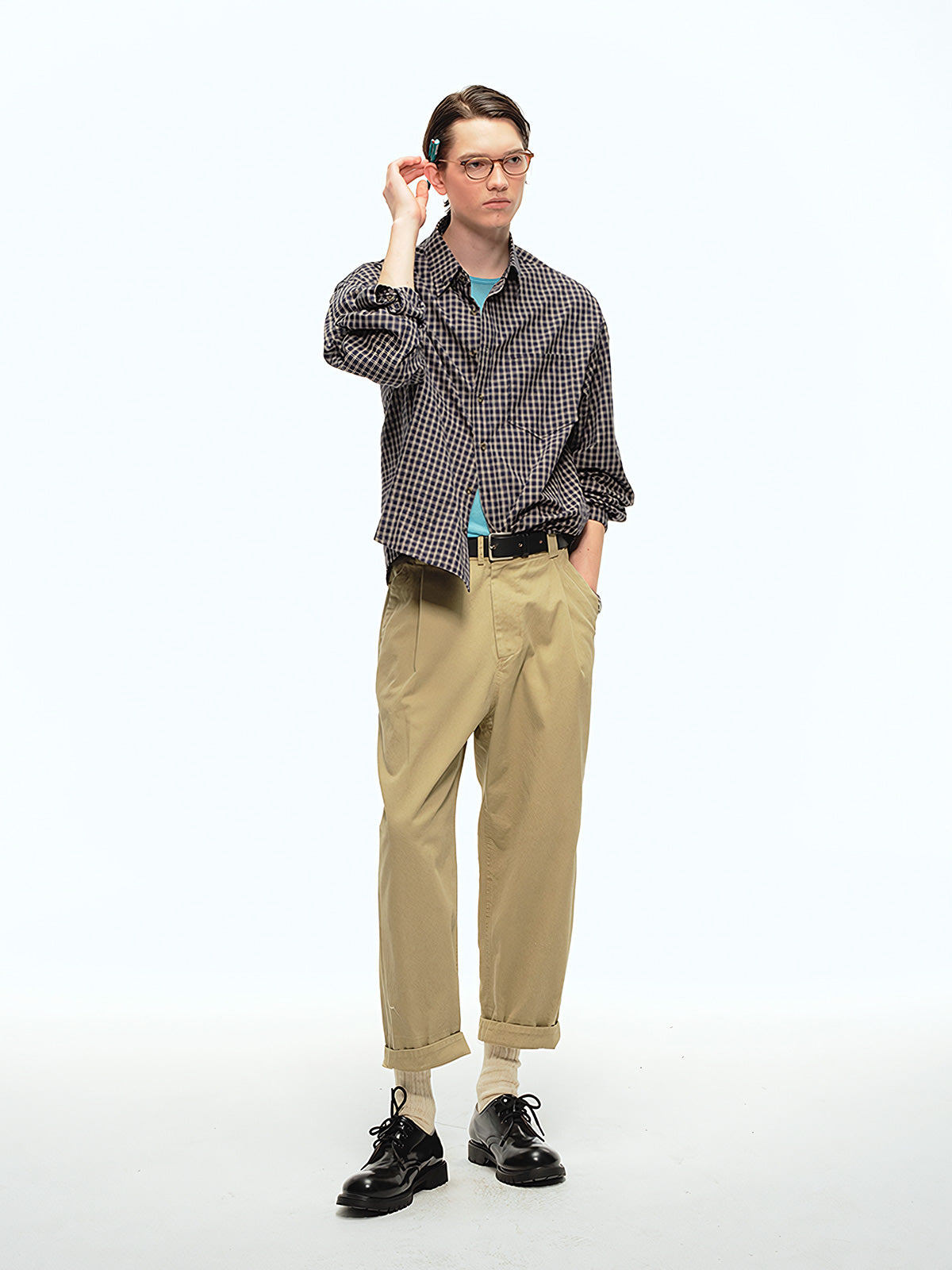 詳細画像: ウエストのプリーツディテールとサンドウォッシュ加工のクローズアップ、自然な色褪せ感と立体感を強調
モデル画像: モデルが九分テーパードカジュアルパンツを着用し、ヴィンテージファッションスタイルを演出、シンプルで洗練されたコーディネート