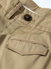 製品画像: サンドウォッシュ加工を施した九分テーパードカジュアルパンツ全体展示、ヴィンテージ風の質感とクラシックなストレートカット
詳細画像: ウエストのプリーツディテールとサンドウォッシュ加工のクローズアップ、自然な色褪せ感と立体感を強調