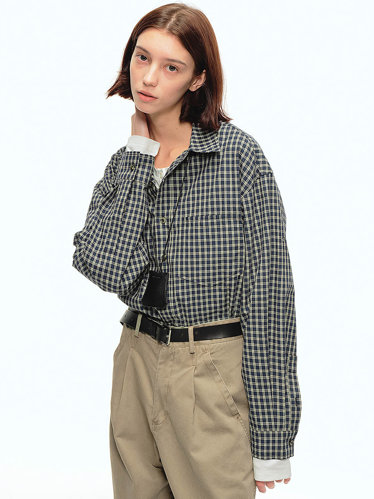 詳細画像: チェック柄と胸部ポケットのユニークなディテール特写、柔らかな肌触りと通気性を強調したコットン素材
モデル画像: チェック柄ショート丈シャツをカジュアルパンツと合わせたスタイリッシュな日常スタイル、レトロ感と現代的な要素を融合