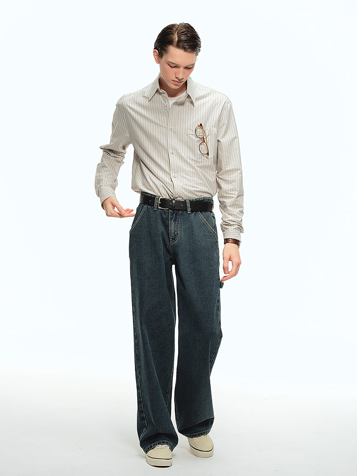 詳細画像: ブルーの細ストライプと胸元のポケットディテール特写、ヴィンテージカットが強調された部分
モデル画像: モデルが100%コットンストライプシャツを着用し、シンプルでヴィンテージ感のあるカジュアルスタイルを披露