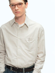 詳細画像: ブルーの細ストライプと胸元のポケットディテール特写、ヴィンテージカットが強調された部分
モデル画像: モデルが100%コットンストライプシャツを着用し、シンプルでヴィンテージ感のあるカジュアルスタイルを披露