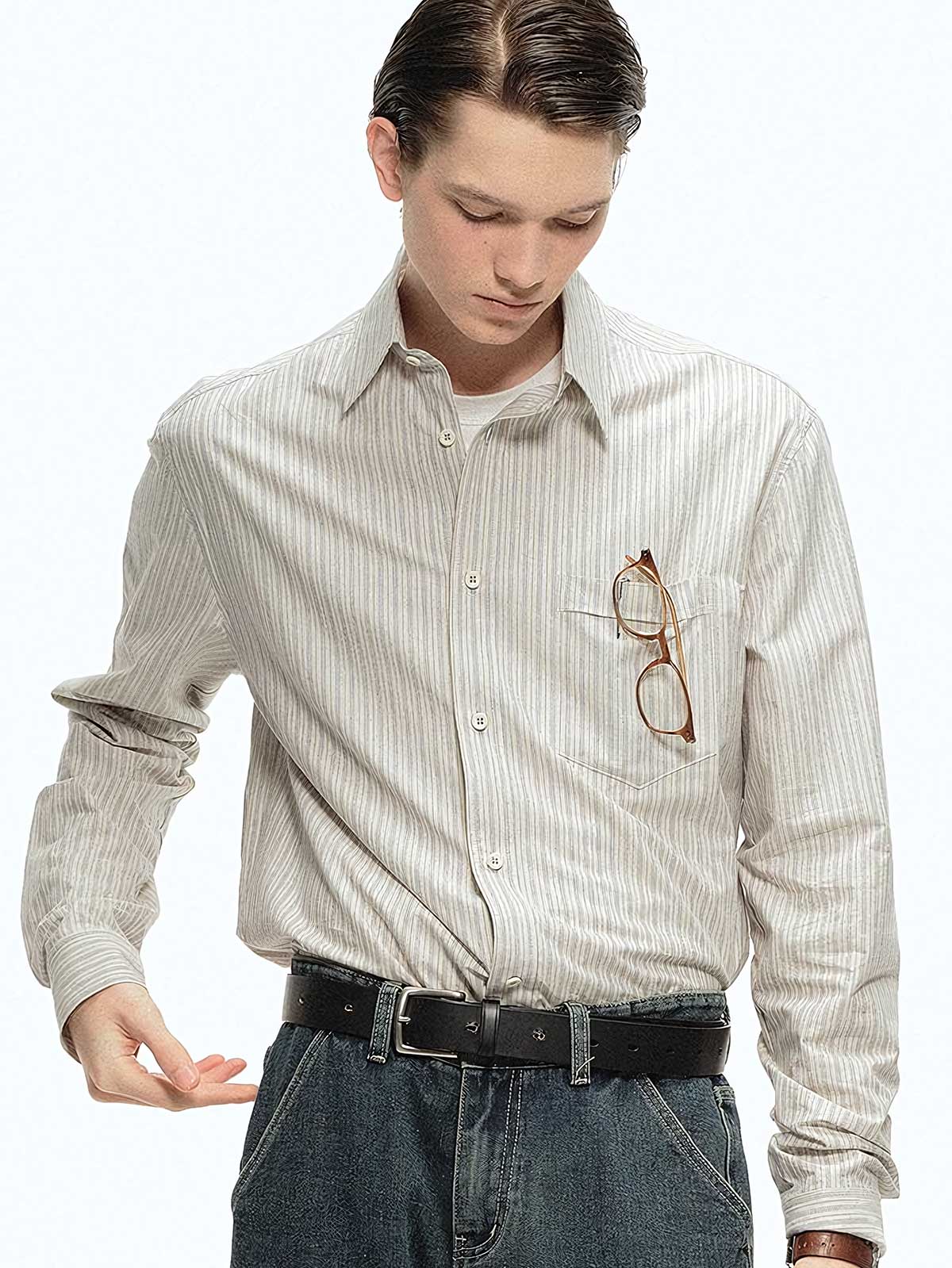 詳細画像: ブルーの細ストライプと胸元のポケットディテール特写、ヴィンテージカットが強調された部分
モデル画像: モデルが100%コットンストライプシャツを着用し、シンプルでヴィンテージ感のあるカジュアルスタイルを披露