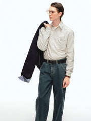 詳細画像: ブルーの細ストライプと胸元のポケットディテール特写、ヴィンテージカットが強調された部分
モデル画像: モデルが100%コットンストライプシャツを着用し、シンプルでヴィンテージ感のあるカジュアルスタイルを披露