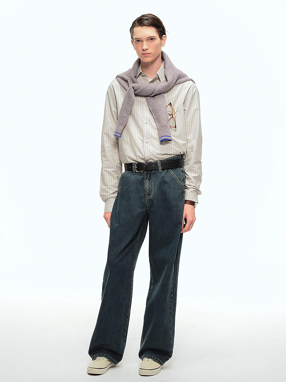 詳細画像: ブルーの細ストライプと胸元のポケットディテール特写、ヴィンテージカットが強調された部分
モデル画像: モデルが100%コットンストライプシャツを着用し、シンプルでヴィンテージ感のあるカジュアルスタイルを披露