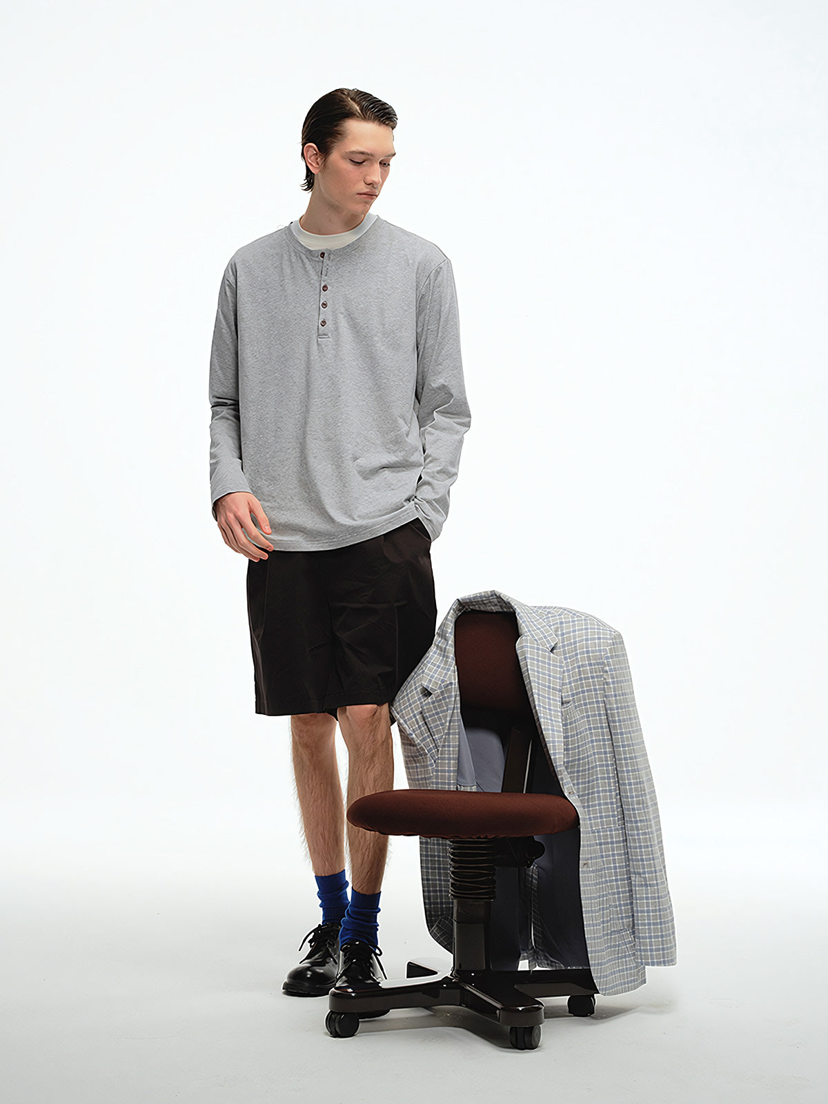 詳細画像: ヘンリーネックのボタンディテールとヘビーコットン生地のクローズアップ、質感と耐久性を強調した部分
モデル画像: モデルがヘンリーネック長袖Tシャツを着用し、アメリカンカジュアルスタイルを演出、シンプルでリラックスしたコーディネート