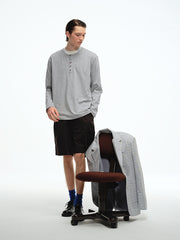 詳細画像: ヘンリーネックのボタンディテールとヘビーコットン生地のクローズアップ、質感と耐久性を強調した部分
モデル画像: モデルがヘンリーネック長袖Tシャツを着用し、アメリカンカジュアルスタイルを演出、シンプルでリラックスしたコーディネート