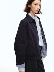 詳細画像: 袖口のバイカラー折り返しデザインとリバーシブルデザインのディテール、ヴィンテージチェック柄と単色面が交互に見える部分のクローズアップ
モデル画像: モデルがリバーシブルハリントンジャケットを使ったヴィンテージ感とモダンなコーディネート、カジュアルなスタイルを披露