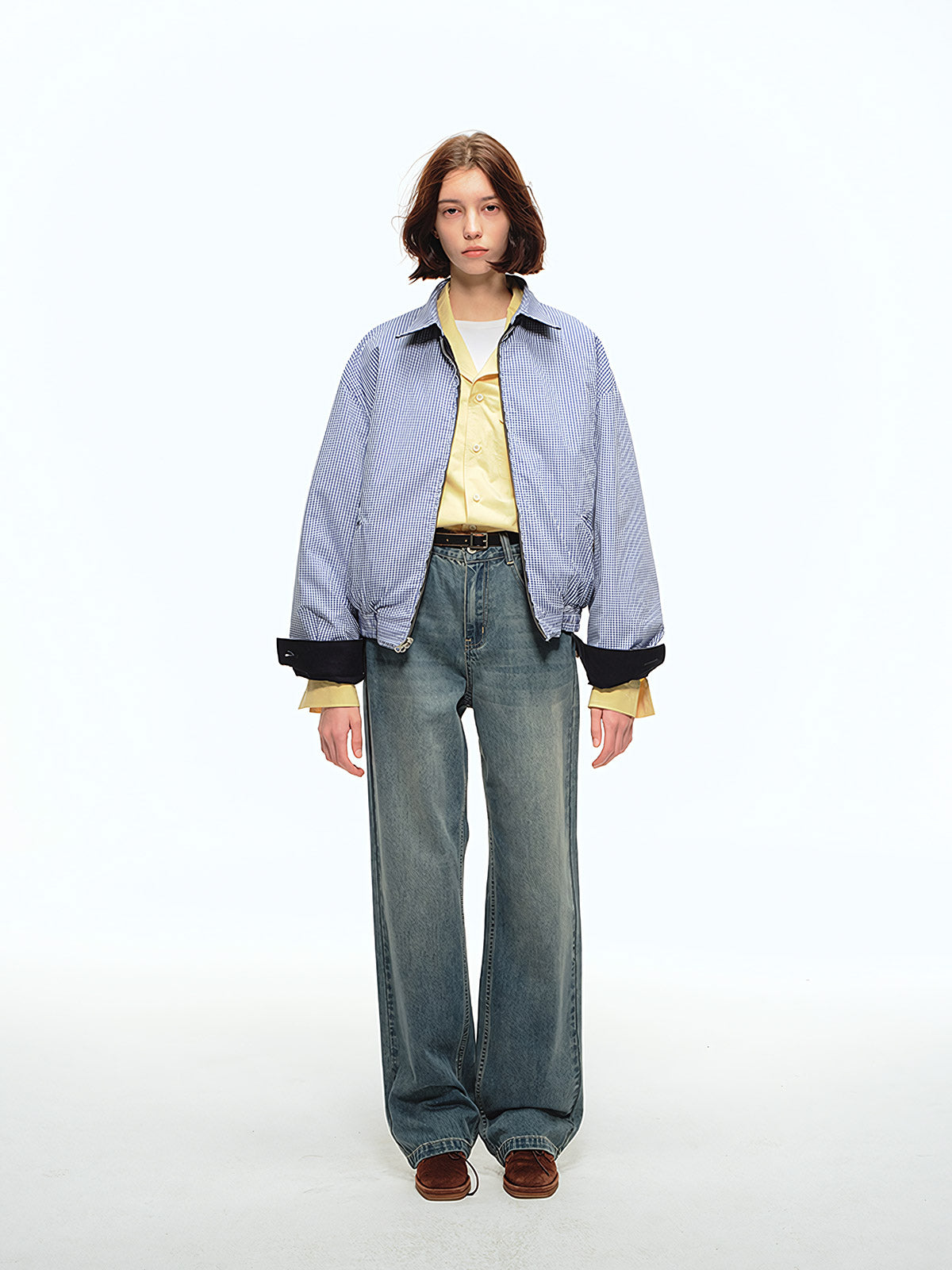 詳細画像: 袖口のバイカラー折り返しデザインとリバーシブルデザインのディテール、ヴィンテージチェック柄と単色面が交互に見える部分のクローズアップ
モデル画像: モデルがリバーシブルハリントンジャケットを使ったヴィンテージ感とモダンなコーディネート、カジュアルなスタイルを披露