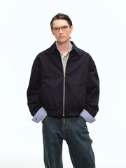 詳細画像: 袖口のバイカラー折り返しデザインとリバーシブルデザインのディテール、ヴィンテージチェック柄と単色面が交互に見える部分のクローズアップ
モデル画像: モデルがリバーシブルハリントンジャケットを使ったヴィンテージ感とモダンなコーディネート、カジュアルなスタイルを披露