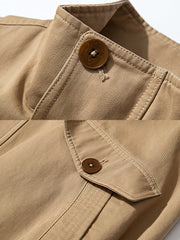 製品画像: ドレーピング(立体裁断)技法を活かしたスタンドカラーのワークジャケット全体展示、サンドウォッシュ加工とコーマコットン素材を使用したヴィンテージ感のあるデザイン
詳細画像: ドレーピングカットによる立体感、スタンドカラーのディテール、大容量ポケットのクローズアップ
