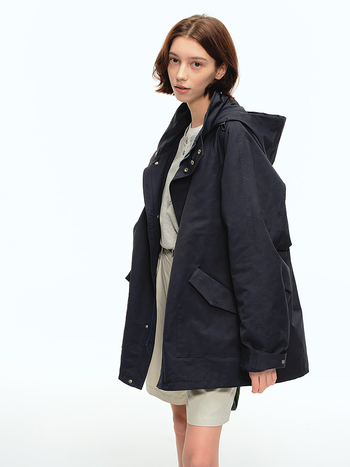 詳細画像: 収納可能なフードと斜めポケットディテール、裾と袖口のデザイン特写、風を防ぎ暖かさを保持する機能的なディテール
モデル画像: モデルがオーバーサイズマウンテンパーカーとカーゴパンツを合わせたヴィンテージで実用的なスタイル、アウトドアや通勤に適したカジュアルコーディネート