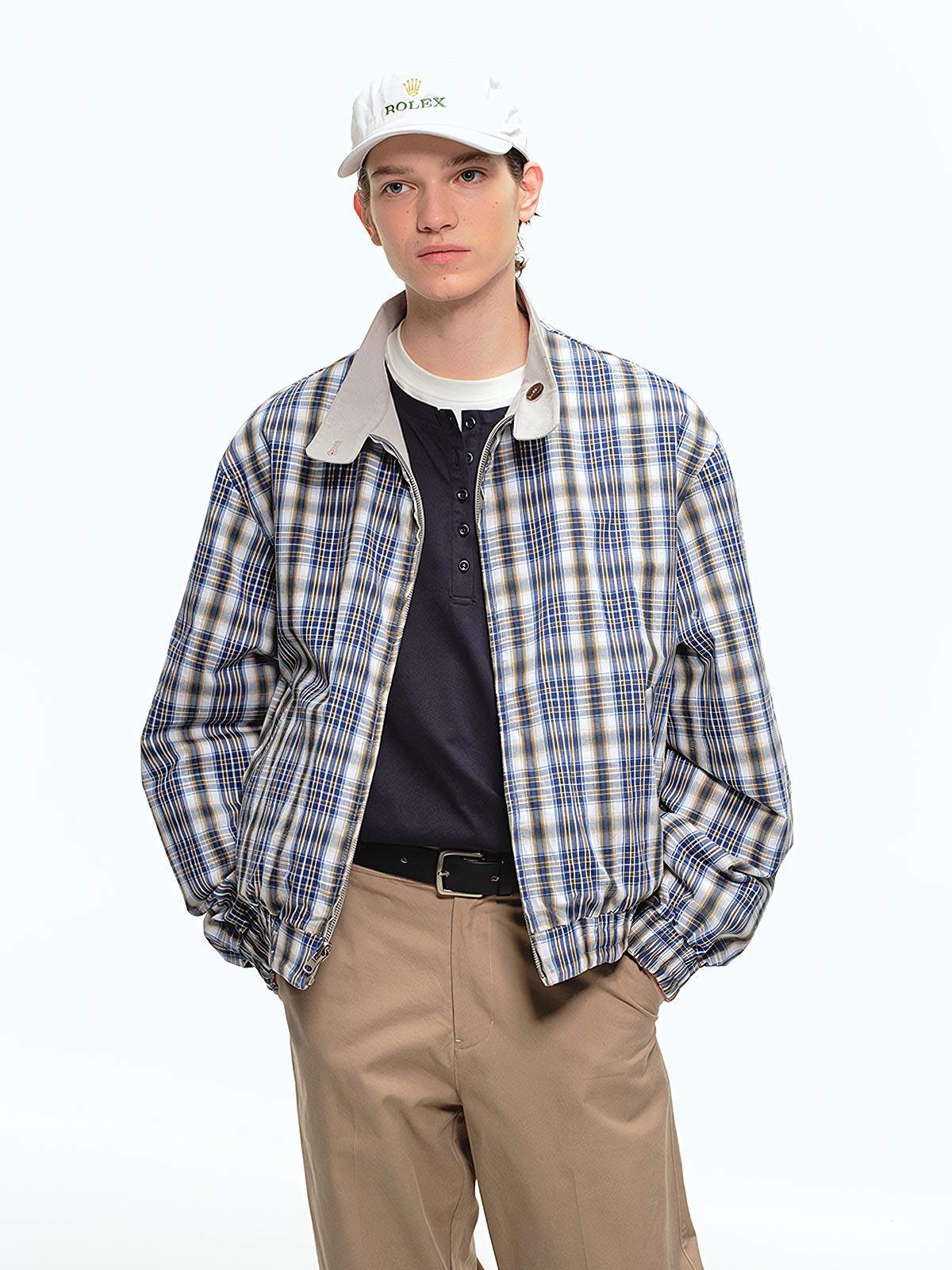 詳細画像: このジャケットの詳細な画像には、チェック柄と無地のリバーシブルデザインがしっかりと反映されており、スタンドカラーのディテール、ジッパー付きのデザイン、リブ袖口と風防デザインが見事に融合して、機能性とデザイン性を兼ね備えた仕上がりとなっています。また、内側のチェック柄ディテールも鮮明に見えるクローズアップで、品質感を際立たせています。
モデル画像: モデル画像では、このリバーシブルハリントンジャケットがカジュアルジーンズと合わせて着用され、レトロスタイルが強調されており、快適でエレガントなコーディネートが演出されています。ジャケットの多機能性とファッション性が一目でわかるスタイルです。