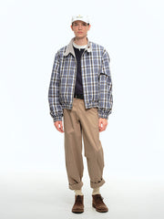 詳細画像: このジャケットの詳細な画像には、チェック柄と無地のリバーシブルデザインがしっかりと反映されており、スタンドカラーのディテール、ジッパー付きのデザイン、リブ袖口と風防デザインが見事に融合して、機能性とデザイン性を兼ね備えた仕上がりとなっています。また、内側のチェック柄ディテールも鮮明に見えるクローズアップで、品質感を際立たせています。
モデル画像: モデル画像では、このリバーシブルハリントンジャケットがカジュアルジーンズと合わせて着用され、レトロスタイルが強調されており、快適でエレガントなコーディネートが演出されています。ジャケットの多機能性とファッション性が一目でわかるスタイルです。