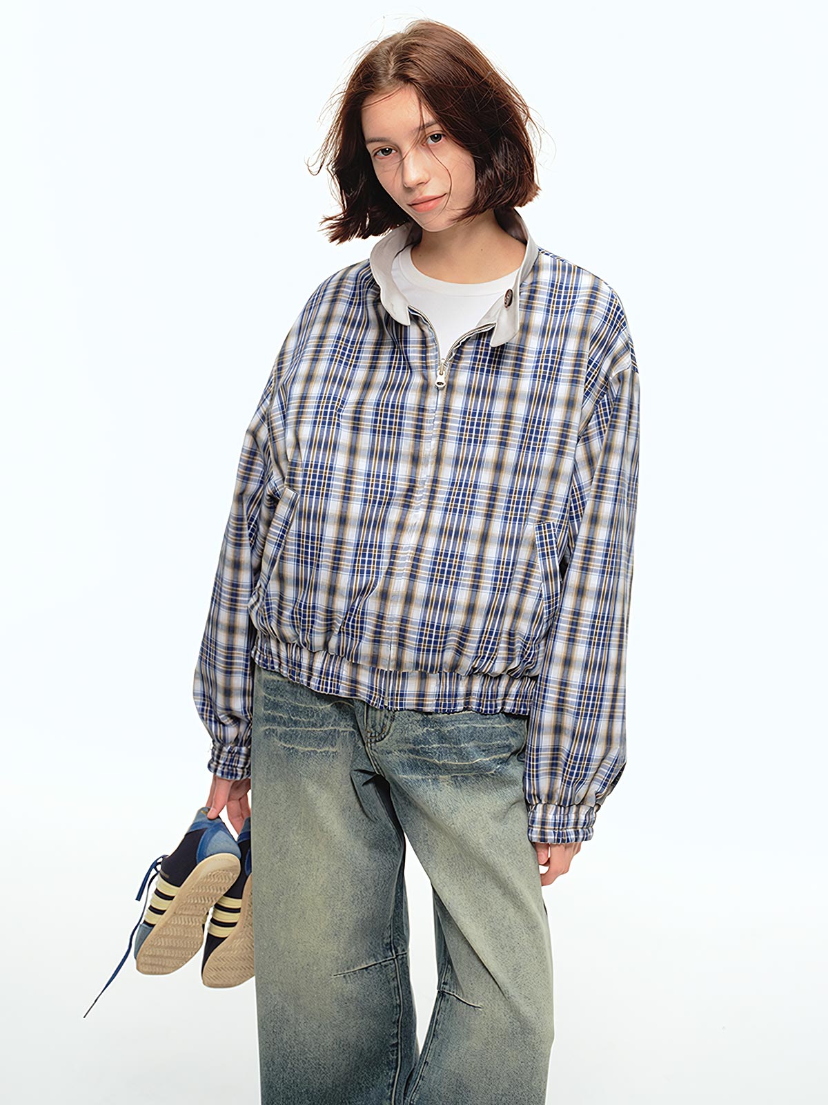 詳細画像: このジャケットの詳細な画像には、チェック柄と無地のリバーシブルデザインがしっかりと反映されており、スタンドカラーのディテール、ジッパー付きのデザイン、リブ袖口と風防デザインが見事に融合して、機能性とデザイン性を兼ね備えた仕上がりとなっています。また、内側のチェック柄ディテールも鮮明に見えるクローズアップで、品質感を際立たせています。
モデル画像: モデル画像では、このリバーシブルハリントンジャケットがカジュアルジーンズと合わせて着用され、レトロスタイルが強調されており、快適でエレガントなコーディネートが演出されています。ジャケットの多機能性とファッション性が一目でわかるスタイルです。