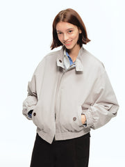 詳細画像: このジャケットの詳細な画像には、チェック柄と無地のリバーシブルデザインがしっかりと反映されており、スタンドカラーのディテール、ジッパー付きのデザイン、リブ袖口と風防デザインが見事に融合して、機能性とデザイン性を兼ね備えた仕上がりとなっています。また、内側のチェック柄ディテールも鮮明に見えるクローズアップで、品質感を際立たせています。
モデル画像: モデル画像では、このリバーシブルハリントンジャケットがカジュアルジーンズと合わせて着用され、レトロスタイルが強調されており、快適でエレガントなコーディネートが演出されています。ジャケットの多機能性とファッション性が一目でわかるスタイルです。