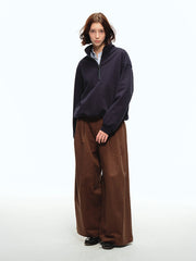 詳細画像: スタンドカラーとレザーパイピングのディテール特写。エコレザーの質感とハーフジップのディテールが強調され、デザイン性と実用性を高めています。
モデル画像: ハーフジップスウェットとカジュアルパンツを合わせたレトロで快適なスタイル。Boxyシルエットがリラックス感を与え、日常使いに最適なスタイリングを披露しています。