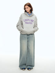 詳細画像: フードとアルファベットプリントのディテール特写。高品質な360Gヘビーウェイトニット素材と、しっかりとしたプリントディテールが強調され、デザイン性と実用性を兼ね備えたパーカー。
モデル画像: パーカーとジーンズを合わせたカジュアルでレトロなスタイル。ルーズフィットデザインがリラックス感を与え、ヴィンテージとモダンが融合したスタイルを披露。