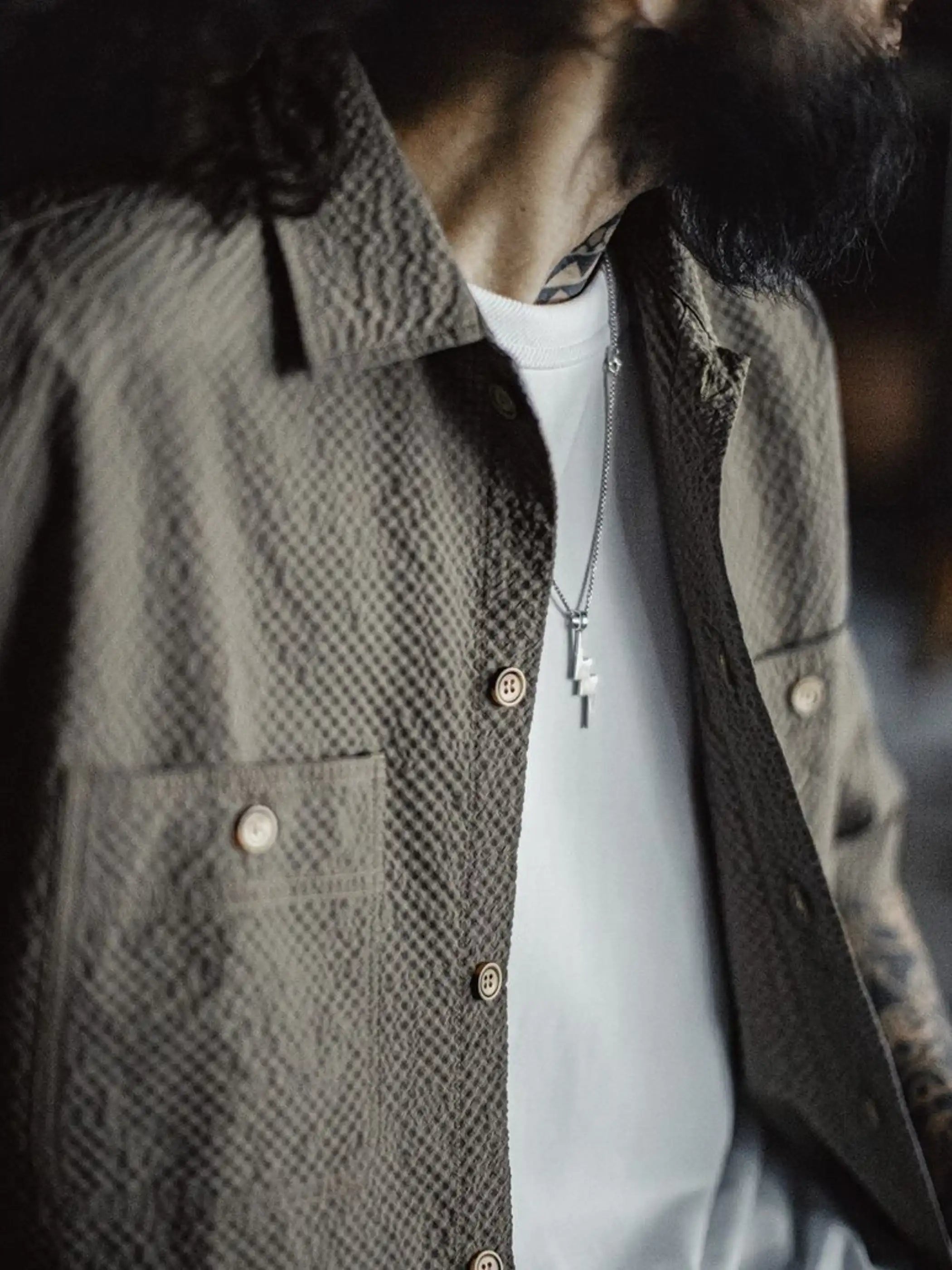 グレーのシアサッカー生地で仕立てられたワークシャツ、2つのフラップポケットがフロントに並ぶ