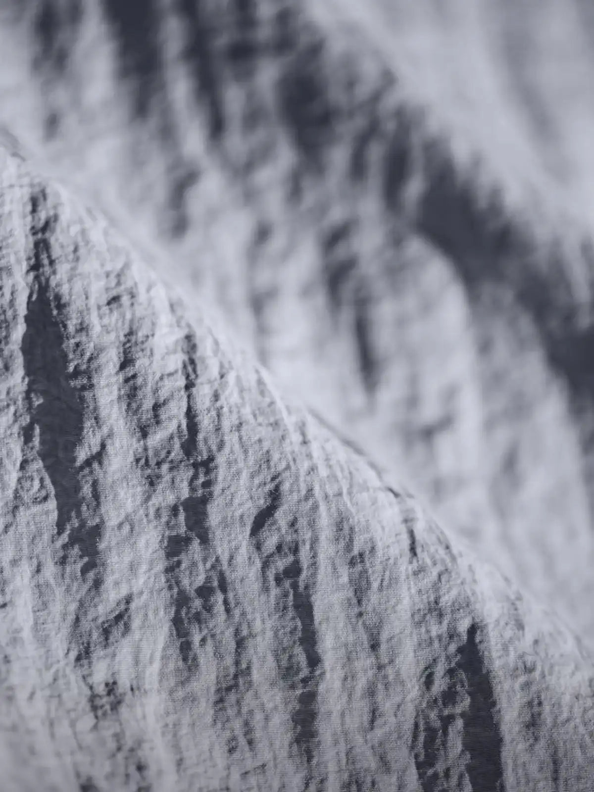 薄手のナイロン生地と2つの胸ポケットが特徴の半袖シャツ正面全体。肩のロゴ刺繍や控えめなスタイリングがわかる