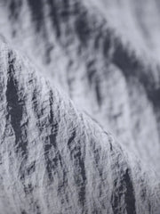 薄手のナイロン生地と2つの胸ポケットが特徴の半袖シャツ正面全体。肩のロゴ刺繍や控えめなスタイリングがわかる