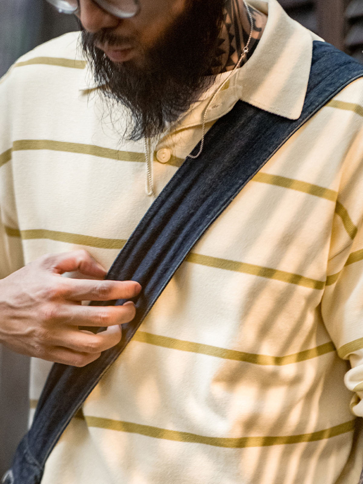 モデルがストライプニットポロシャツを着用し、カジュアルなヴィンテージコーデを披露