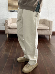 モデルがツイルウォッシュドソリッドカラーワークパンツを着用し、シンプルなTシャツと丈夫なブーツでスタイリング。この組み合わせがアウトドアアクティビティやカジュアルな日常に最適なリラックスしたスタイルを提供しています。