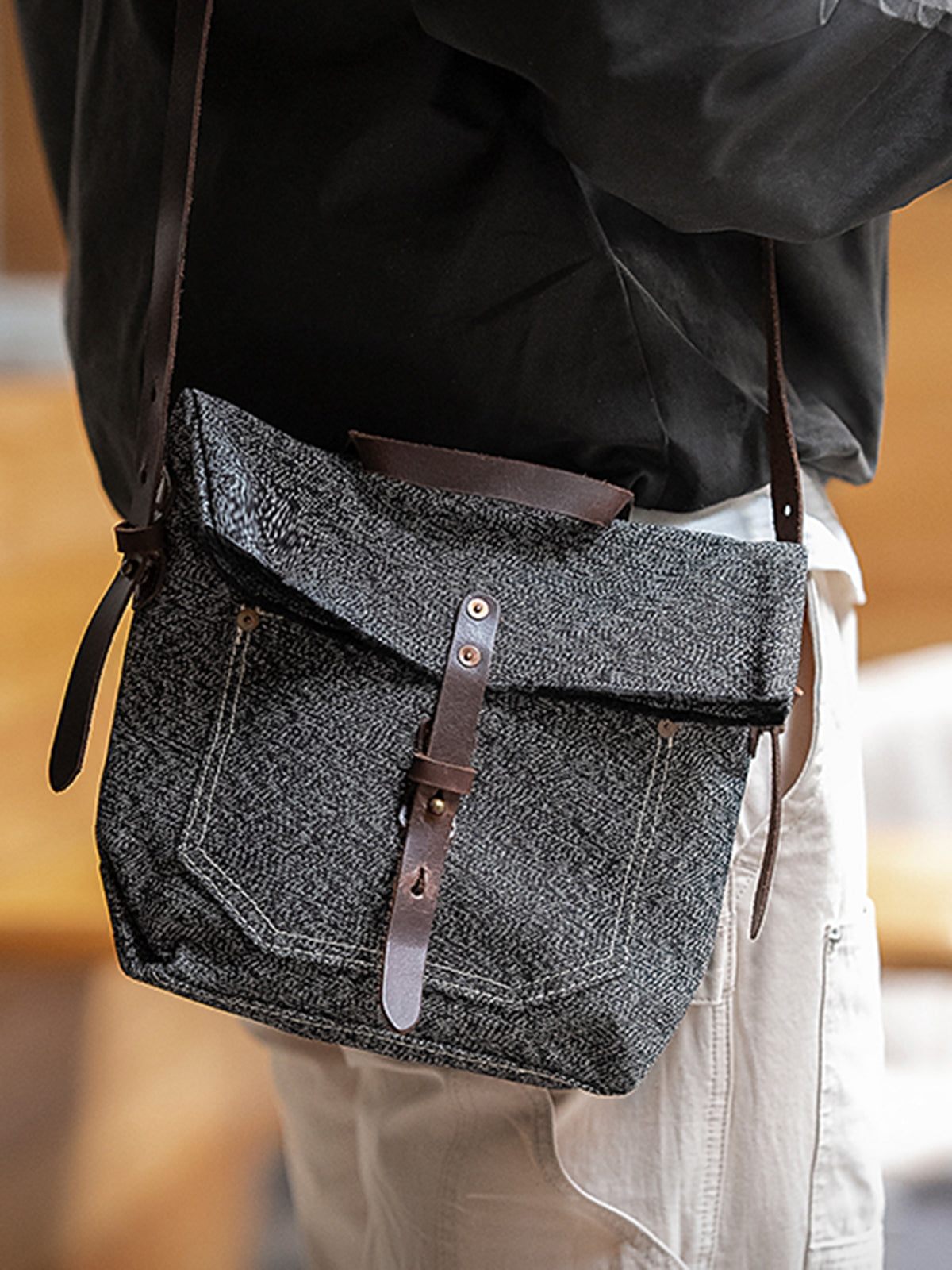 モデル画像: モデルがヴィンテージスタイルのメッセンジャーバッグを持っている様子