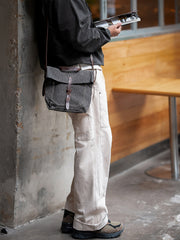 モデル画像: モデルがヴィンテージスタイルのメッセンジャーバッグを持っている様子