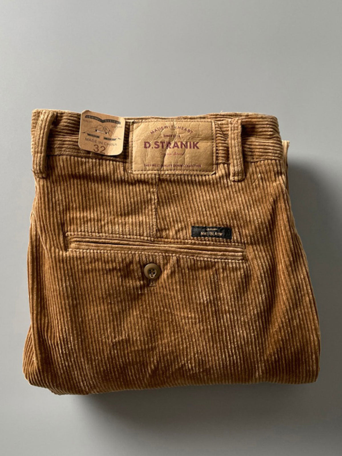 製品画像
高密度の14畝コーデュロイ素材を使用したストレートカーゴパンツ。クラシックなストレートシルエットとウォッシュ加工によるヴィンテージ感が特徴で、鉱山作業着の伝統を受け継ぐデザインが際立つ
詳細画像
バックポケットに施された二重補強ディテールとウエスト内側の丁寧なパイピング仕上げが、機能性とクラシックな仕立ての美学を象徴。コーデュロイの均一な畝立ちが繊細な質感を強調