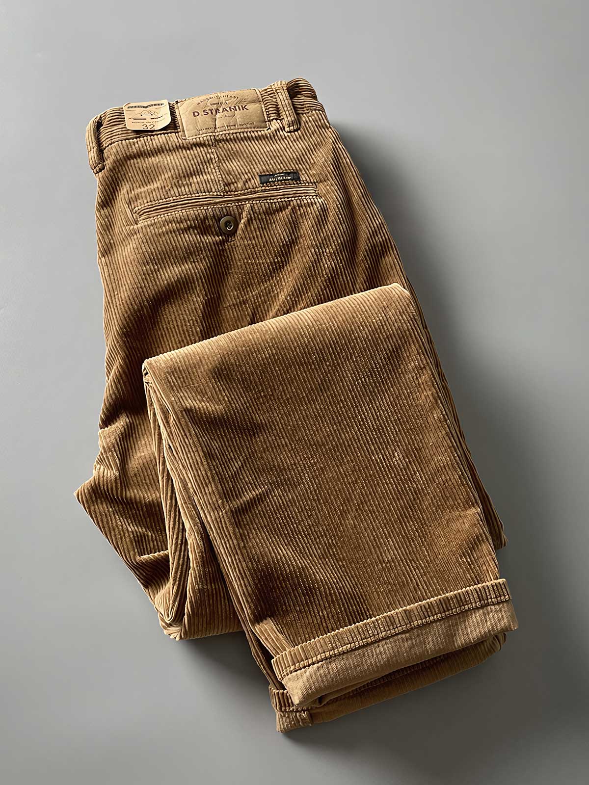 製品画像
高密度の14畝コーデュロイ素材を使用したストレートカーゴパンツ。クラシックなストレートシルエットとウォッシュ加工によるヴィンテージ感が特徴で、鉱山作業着の伝統を受け継ぐデザインが際立つ
詳細画像
バックポケットに施された二重補強ディテールとウエスト内側の丁寧なパイピング仕上げが、機能性とクラシックな仕立ての美学を象徴。コーデュロイの均一な畝立ちが繊細な質感を強調