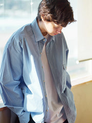 詳細画像: 胸ポケットとストライプ柄のディテール特写。精緻な織り目と均一なデザインが、ヴィンテージ感を引き立てつつ、現代的なカジュアルさも加えています。クロスステッチでの仕上げが、デザインの深みと耐久性を強調。
モデル画像: レトロストライプシャツとルーズパンツを合わせたカジュアルヴィンテージスタイル。ドロップショルダーとやや短めの丈が、現代的なカジュアル感を加え、快適で動きやすいシルエットを演出します。