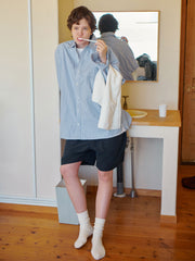 詳細画像: 胸ポケットとストライプ柄のディテール特写。精緻な織り目と均一なデザインが、ヴィンテージ感を引き立てつつ、現代的なカジュアルさも加えています。クロスステッチでの仕上げが、デザインの深みと耐久性を強調。
モデル画像: レトロストライプシャツとルーズパンツを合わせたカジュアルヴィンテージスタイル。ドロップショルダーとやや短めの丈が、現代的なカジュアル感を加え、快適で動きやすいシルエットを演出します。