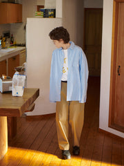 詳細画像: 胸ポケットとストライプ柄のディテール特写。精緻な織り目と均一なデザインが、ヴィンテージ感を引き立てつつ、現代的なカジュアルさも加えています。クロスステッチでの仕上げが、デザインの深みと耐久性を強調。
モデル画像: レトロストライプシャツとルーズパンツを合わせたカジュアルヴィンテージスタイル。ドロップショルダーとやや短めの丈が、現代的なカジュアル感を加え、快適で動きやすいシルエットを演出します。