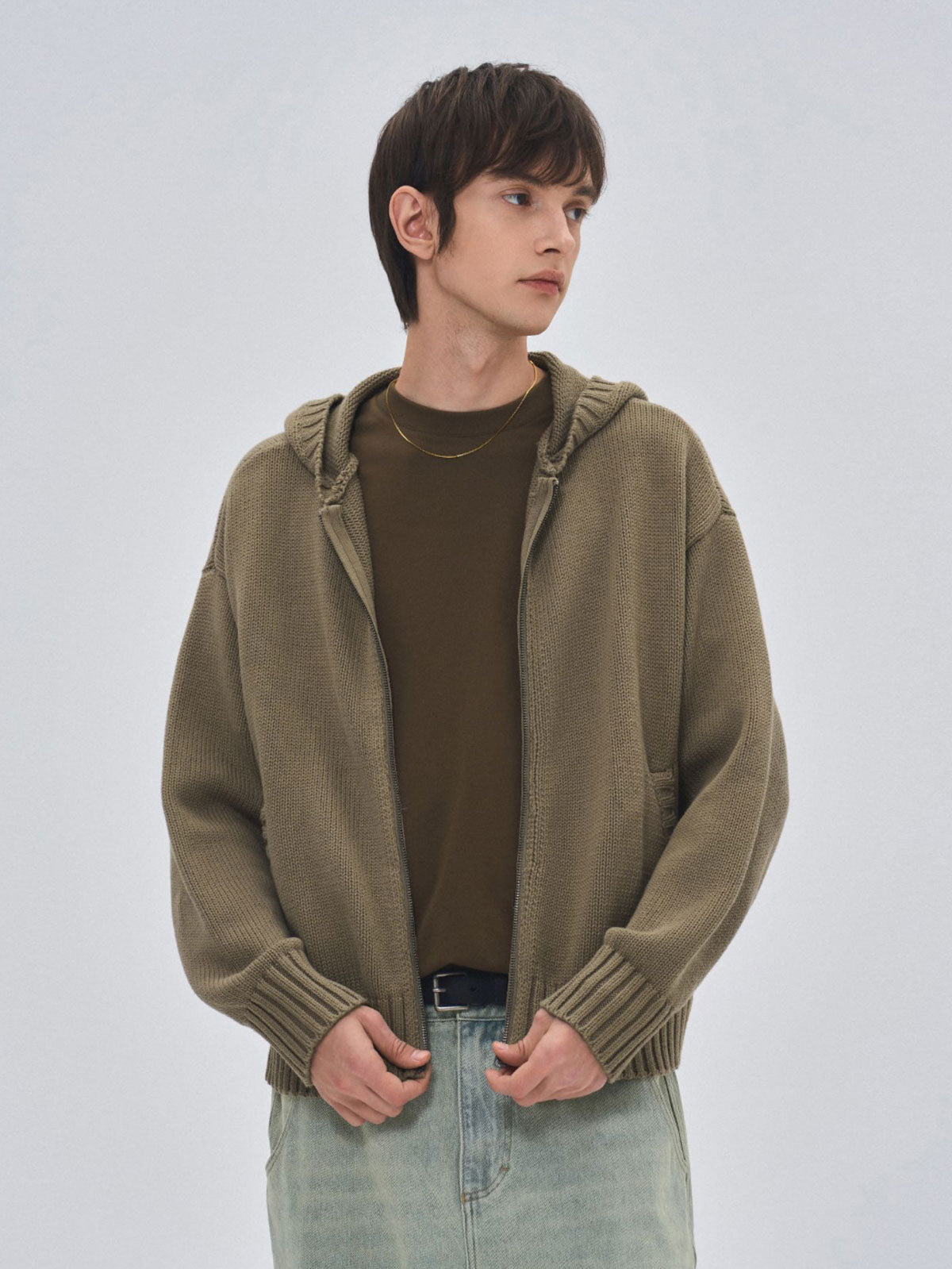 詳細画像: ケーブル編みディテールとマットシルバージッパーの特写。細部の編み模様とジッパーが際立つ画像。
モデル画像: ケーブル編みカーディガンとデニムを組み合わせた秋冬カジュアルスタイル。モデルがリラックスした日常スタイルを披露。