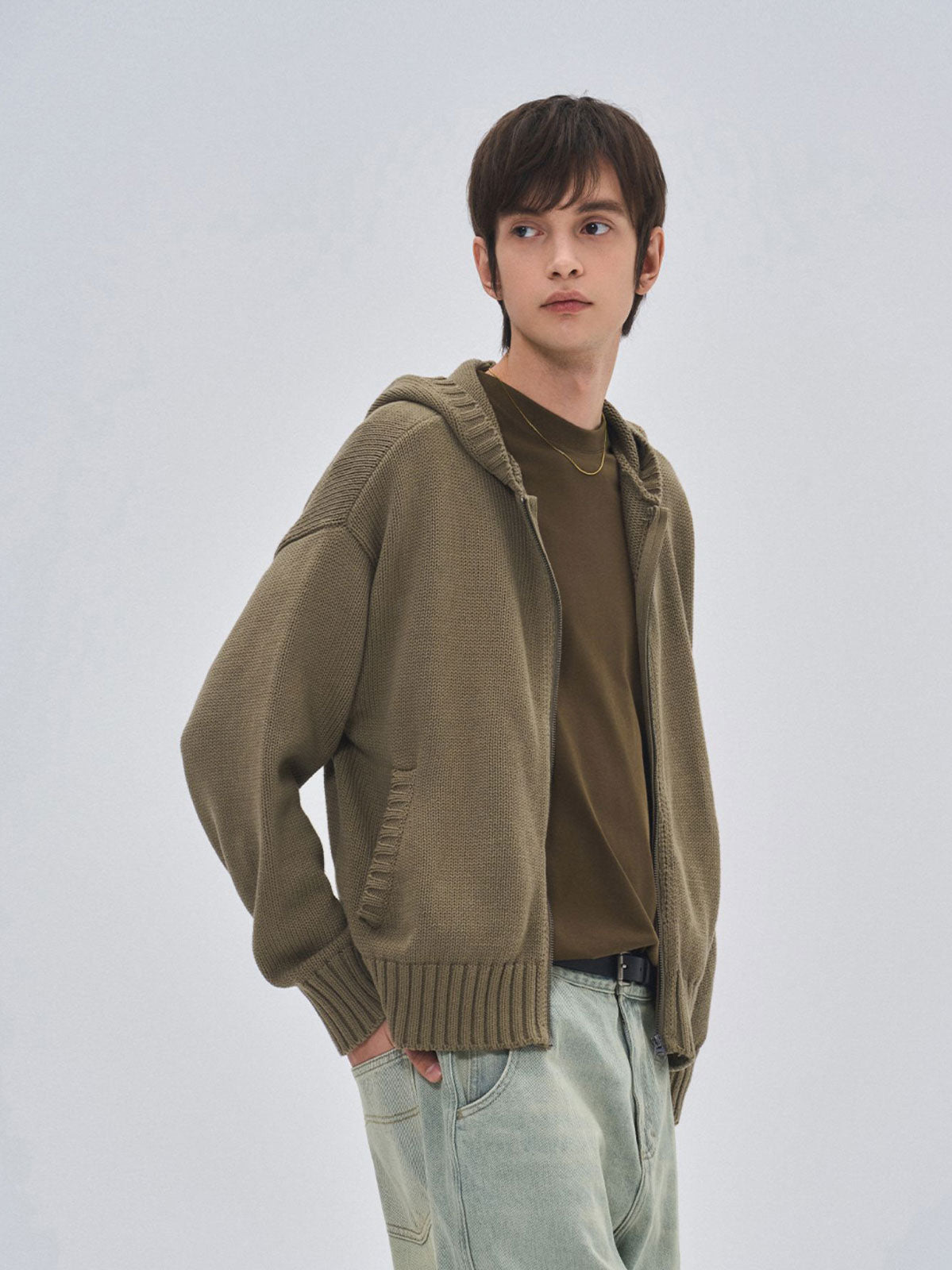 詳細画像: ケーブル編みディテールとマットシルバージッパーの特写。細部の編み模様とジッパーが際立つ画像。
モデル画像: ケーブル編みカーディガンとデニムを組み合わせた秋冬カジュアルスタイル。モデルがリラックスした日常スタイルを披露。