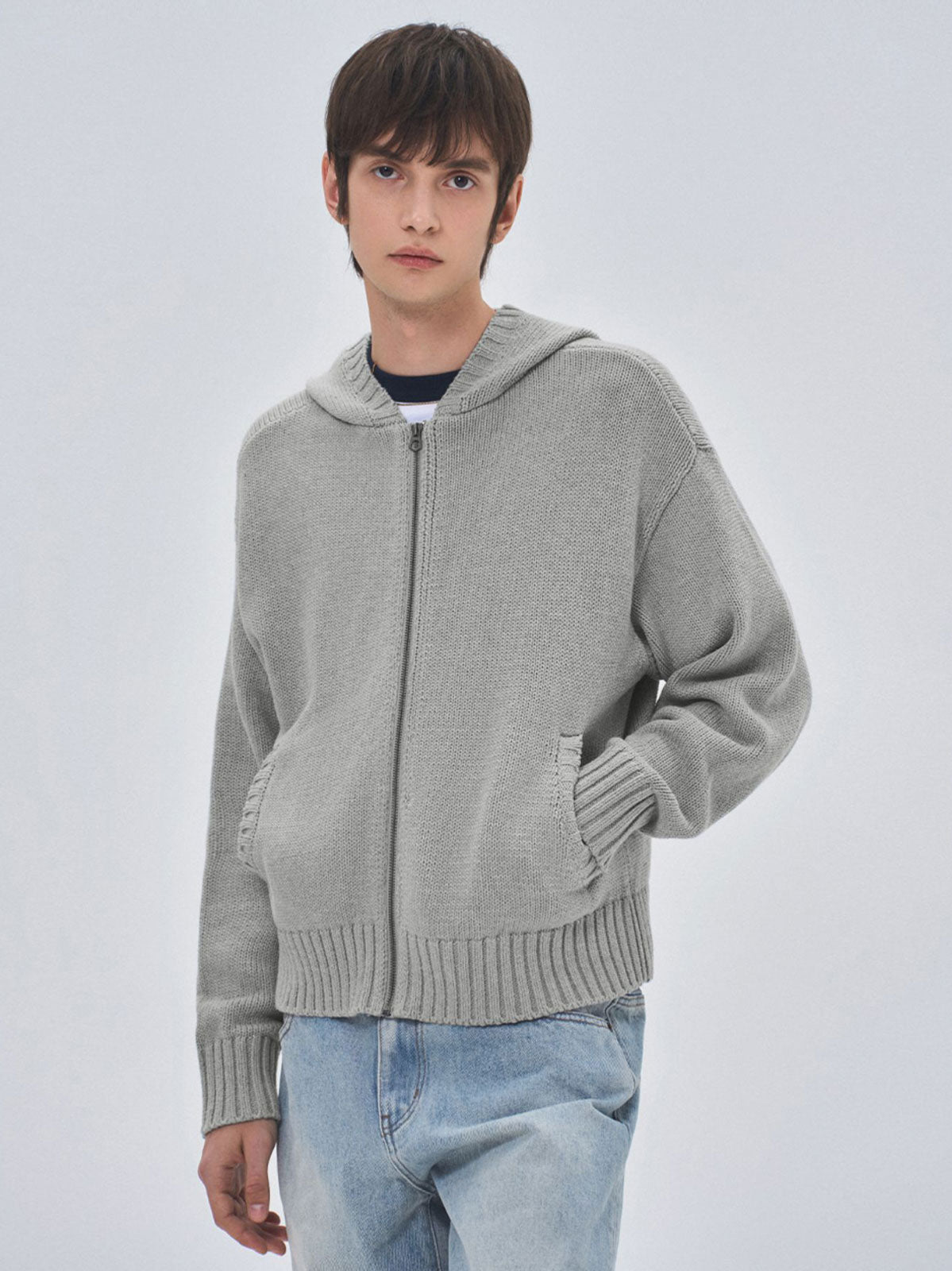 詳細画像: ケーブル編みディテールとマットシルバージッパーの特写。細部の編み模様とジッパーが際立つ画像。
モデル画像: ケーブル編みカーディガンとデニムを組み合わせた秋冬カジュアルスタイル。モデルがリラックスした日常スタイルを披露。