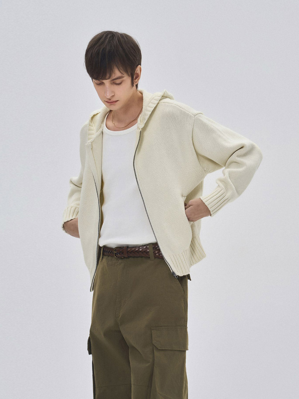 詳細画像: ケーブル編みディテールとマットシルバージッパーの特写。細部の編み模様とジッパーが際立つ画像。
モデル画像: ケーブル編みカーディガンとデニムを組み合わせた秋冬カジュアルスタイル。モデルがリラックスした日常スタイルを披露。