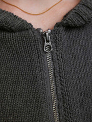 詳細画像: ケーブル編みディテールとマットシルバージッパーの特写。細部の編み模様とジッパーが際立つ画像。
モデル画像: ケーブル編みカーディガンとデニムを組み合わせた秋冬カジュアルスタイル。モデルがリラックスした日常スタイルを披露。