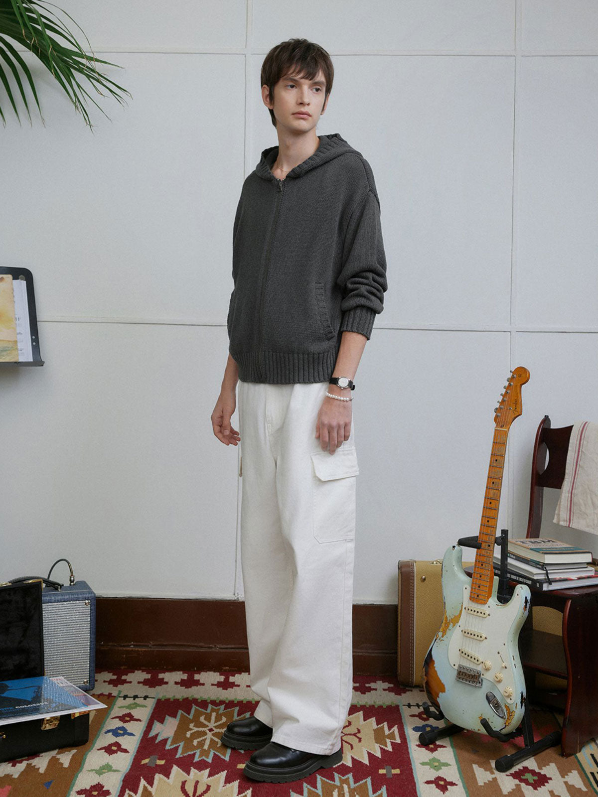 詳細画像: ケーブル編みディテールとマットシルバージッパーの特写。細部の編み模様とジッパーが際立つ画像。
モデル画像: ケーブル編みカーディガンとデニムを組み合わせた秋冬カジュアルスタイル。モデルがリラックスした日常スタイルを披露。