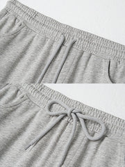 製品画像: レトロなコットン混紡ニットスウェットパンツの全体展示。シンプルなストレートシルエットとロールアップ裾が特徴のカジュアルスウェットパンツ。
詳細画像: ウエスト部分のゴムとドローストリング、裾のロールアップディテール特写。ウエストと裾のデザインが引き立つ特写。