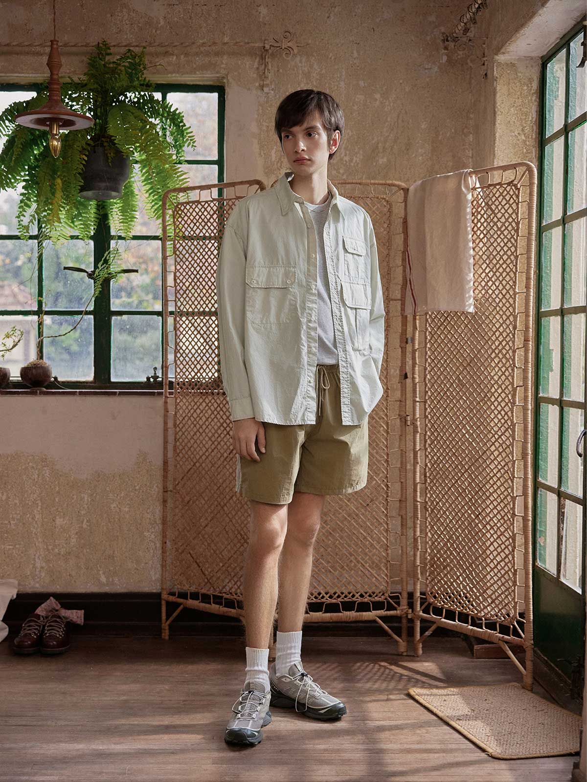 詳細画像: 胸元の3ポケットと酵素洗い加工ディテールの特写。ヴィンテージ感を引き立てるデザインで、機能性とファッション性を兼ね備えた仕上がり。
モデル画像: ワークシャツとアウトドアアイテムを組み合わせたレトロなアウトドアスタイルを披露するモデル。ジーンズやカーゴパンツとの相性も抜群。