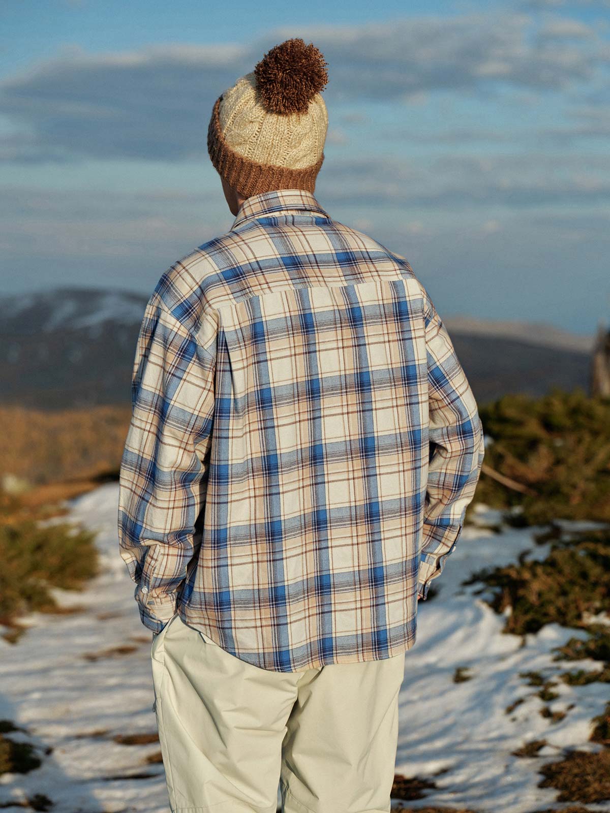 詳細画像: 色褪せしにくい色織り生地と三つポケットのディテール。厚手で暖かい質感が伝わる画像。
モデル画像: モデルが着用した厚手ブルーチェック柄シャツを使ったカジュアルでレトロなスタイリング展示。秋冬シーズンのコーディネート例。