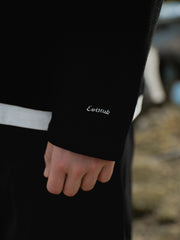 詳細画像: ワッフル生地のテクスチャーとレイヤードデザインの特写。独自の質感とディテールが着こなしに深みを加え、シンプルでありながらもデザイン性が光る。
モデル画像: ヘンリーネック長袖Tシャツを着用したカジュアルなレイヤードスタイルを披露するモデル。ゆったりとしたシルエットと快適さを兼ね備え、スタイリッシュな着こなしを実現。