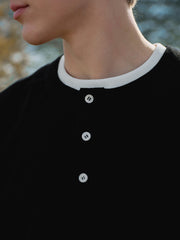 詳細画像: ワッフル生地のテクスチャーとレイヤードデザインの特写。独自の質感とディテールが着こなしに深みを加え、シンプルでありながらもデザイン性が光る。
モデル画像: ヘンリーネック長袖Tシャツを着用したカジュアルなレイヤードスタイルを披露するモデル。ゆったりとしたシルエットと快適さを兼ね備え、スタイリッシュな着こなしを実現。